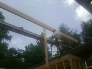 Carpenter setting a ridge beam over a new addition frame — Ice Dam Removal by Roofing Brothers in Valley Village