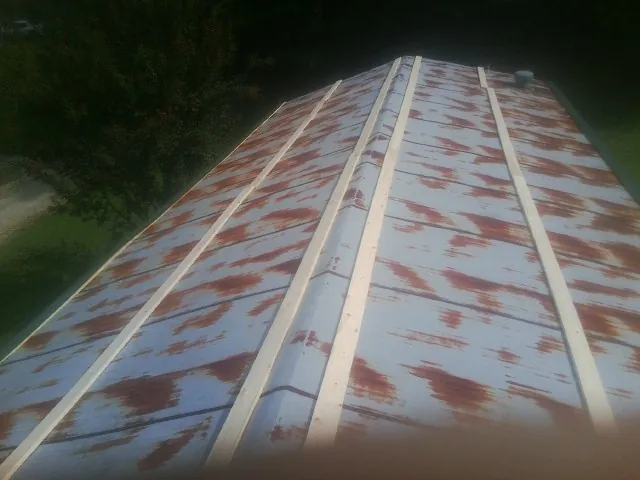 Rusted metal roof panels with new wood purlins before replacement — Storm Damage Roof Repair in Valley Village by Roofing Brothers